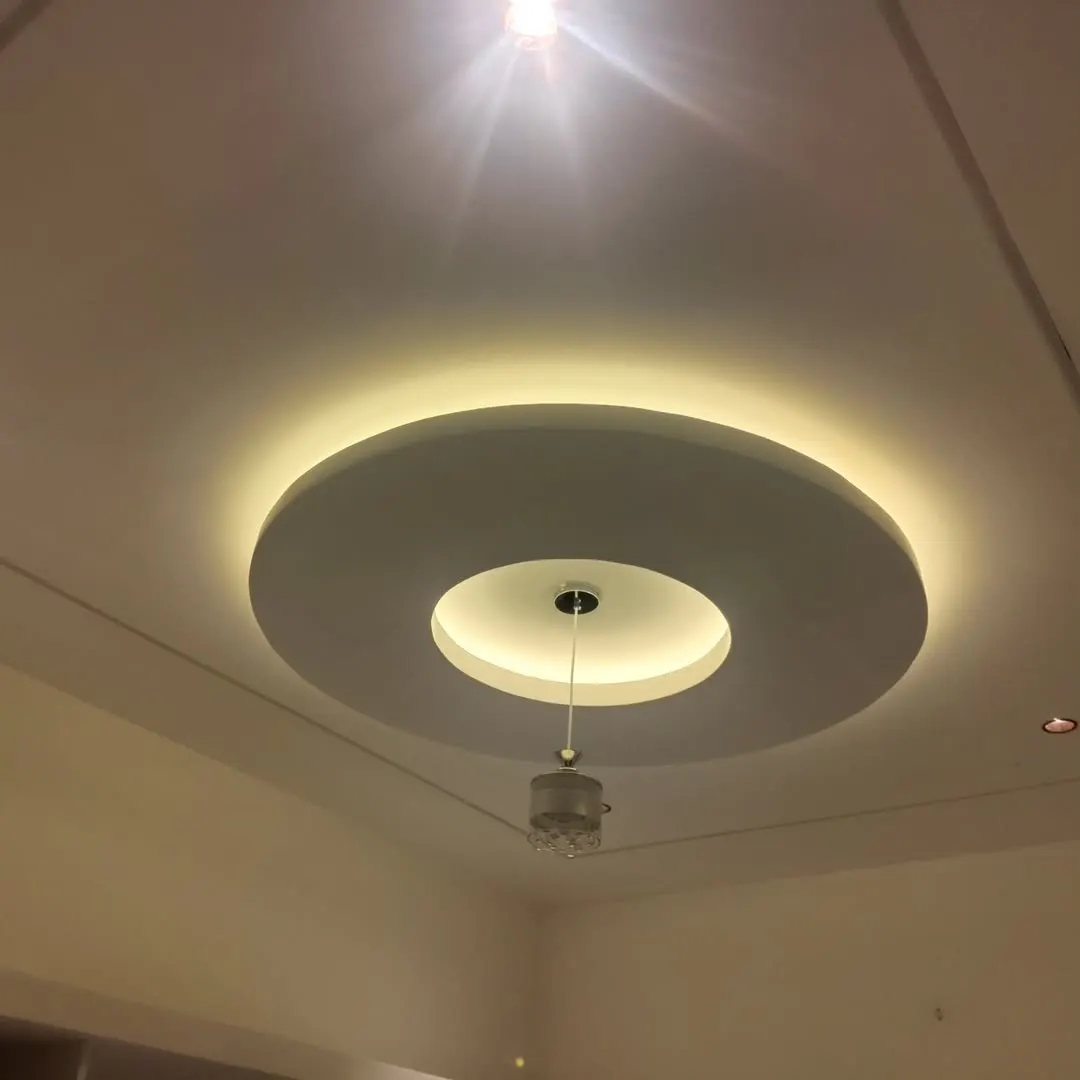 Gypsum false ceiling with a cove-lit border in a Forbesganj living room by JK Interior Gypsum false ceiling with a cove-lit border in a Forbesganj living room by JK Interior